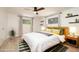This staged main bedroom offers a ceiling fan, wood-look flooring, a king-sized bed, and decorative shelves at 1600 Lonesome Pine Ln, Tarpon Springs, FL 34689