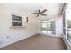 Enclosed sunroom with carpet, a ceiling fan, and sliding windows leading to outdoor views at 1600 Lonesome Pine Ln, Tarpon Springs, FL 34689