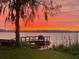 Stunning sunset view from the lake with a dock at 1600 Lonesome Pine Ln, Tarpon Springs, FL 34689