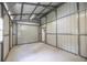 Spacious metal workshop interior with roll-up door, concrete floors, and natural lighting at 1600 Lonesome Pine Ln, Tarpon Springs, FL 34689