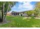 Spacious backyard with a screened lanai, lush lawn, and mature trees providing privacy at 16113 Tampa St, Lutz, FL 33548