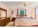 Spacious bedroom with ceiling fan, windows, and carpeted floors at 16113 Tampa St, Lutz, FL 33548