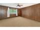 Bedroom with wood paneled walls, carpeted floors, and a window at 16113 Tampa St, Lutz, FL 33548