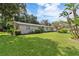 Lush front lawn with mature trees surrounding the home's exterior at 16113 Tampa St, Lutz, FL 33548