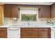 A close up view of the kitchen sink, countertops, and cabinets with a view to the lanai at 16113 Tampa St, Lutz, FL 33548