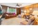 Living room with wood paneled walls, carpeted floors, and comfortable seating area at 16113 Tampa St, Lutz, FL 33548
