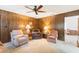 Living room with wood paneled walls, carpeted floors, and comfortable seating area at 16113 Tampa St, Lutz, FL 33548