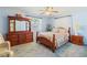 Comfortable main bedroom with a wood bed frame, dresser, and soft blue walls; relaxing retreat at 16113 Tampa St, Lutz, FL 33548