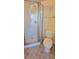 Bathroom featuring a glass-enclosed shower, toilet, and tile flooring at 16501 Harper Pond Ln # 308, Odessa, FL 33556