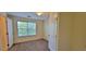 Carpeted bedroom with natural light coming in from a window and a door at 16501 Harper Pond Ln # 308, Odessa, FL 33556