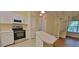 Bright kitchen featuring white cabinets and stainless steel appliances adjacent to spiral staircase at 16501 Harper Pond Ln # 308, Odessa, FL 33556