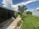 Spacious backyard with a stone path, lawn, palm trees, and seating, perfect for outdoor enjoyment and relaxation at 1710 7Th Sw St # 39, Ruskin, FL 33570