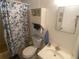 Functional bathroom with a toilet, sink, storage cabinet, and shower curtain, providing essential amenities at 1710 7Th Sw St # 39, Ruskin, FL 33570