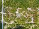 An aerial view of a property that has multiple buildings, a pool and is surrounded by many trees at 17207 Bosley Dr, Spring Hill, FL 34610