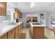 Bright kitchen with oak cabinetry, tiled countertops, and island with cooktop at 17207 Bosley Dr, Spring Hill, FL 34610