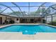 A clear in-ground pool with a screened enclosure and view of the house at 17207 Bosley Dr, Spring Hill, FL 34610