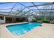 A clear in-ground pool with a screened enclosure and view of the house at 17207 Bosley Dr, Spring Hill, FL 34610