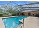 Screened-in pool with a paved deck and pool furniture at 17207 Bosley Dr, Spring Hill, FL 34610