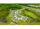 Aerial view of townhomes, manicured lawns, with ponds and trees at 17741 Tawny Malt Pl, Land O Lakes, FL 34638