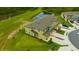 Aerial view of townhomes with manicured lawns and a tranquil pond at 17741 Tawny Malt Pl, Land O Lakes, FL 34638