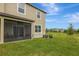 Beautiful backyard featuring a screened porch, lush green lawn, and well-maintained landscaping at 17741 Tawny Malt Pl, Land O Lakes, FL 34638