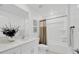 Bright bathroom featuring white cabinets, modern fixtures, and a tub with a shower curtain at 17741 Tawny Malt Pl, Land O Lakes, FL 34638