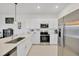 Modern kitchen featuring stainless steel appliances, white cabinets, and quartz countertops at 17741 Tawny Malt Pl, Land O Lakes, FL 34638