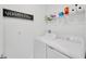 Bright laundry room with white appliances, ample shelving, and stylish 'Wash & Dry' sign at 17741 Tawny Malt Pl, Land O Lakes, FL 34638