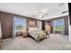 Bright and airy main bedroom with a ceiling fan, plush carpet, and picturesque windows at 17741 Tawny Malt Pl, Land O Lakes, FL 34638