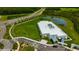 Aerial view of a modern school building, surrounded by green lawns, a pond, and roadways at 17741 Tawny Malt Pl, Land O Lakes, FL 34638