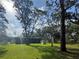 Lush backyard featuring mature trees, pizza oven, a home with a covered porch and a shed at 17926 Calkins Ct, Spring Hill, FL 34610