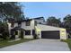 Charming two-story home with dark trim, a driveway, and mature trees at 17926 Calkins Ct, Spring Hill, FL 34610