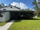 Exterior view of a home with a screened patio, lush lawn, and a sunny sky, great for outdoor enjoyment at 17926 Calkins Ct, Spring Hill, FL 34610