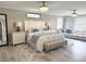 Spacious main bedroom featuring a seating area, crystal ceiling fan, and hardwood floors at 17926 Calkins Ct, Spring Hill, FL 34610