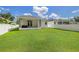 Expansive backyard features a lush lawn and a covered patio perfect for outdoor living at 1803 E Powhatan Ave, Tampa, FL 33610