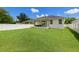 Well-manicured backyard features a green lawn, white fence and patio, offering a private retreat at 1803 E Powhatan Ave, Tampa, FL 33610