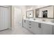 Bright bathroom featuring a double vanity, granite countertops, and a walk-in closet at 1803 E Powhatan Ave, Tampa, FL 33610