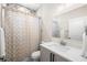 Updated bathroom featuring a modern vanity, decorative shower curtain, and tiled walls at 1803 E Powhatan Ave, Tampa, FL 33610