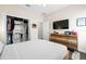Bright bedroom with a TV, closet, hardwood floors, and modern dresser at 1803 E Powhatan Ave, Tampa, FL 33610