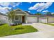 Inviting single-story home with a well-manicured lawn and a spacious driveway leading to the garage at 1803 E Powhatan Ave, Tampa, FL 33610