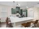 Modern kitchen featuring an island with a quartz countertop and bar seating with forest green cabinets at 1803 E Powhatan Ave, Tampa, FL 33610