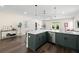 Well-designed kitchen with white countertops and bar stools, flowing into the living room, and dark wood floors at 1803 E Powhatan Ave, Tampa, FL 33610