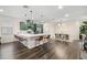 Spacious open-concept kitchen and dining area with dark wood floors, modern lighting, and stylish seating at 1803 E Powhatan Ave, Tampa, FL 33610