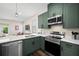 Modern kitchen with stainless steel appliances, shaker cabinets, a stylish faucet, and quartz countertops at 1803 E Powhatan Ave, Tampa, FL 33610