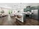 Modern kitchen with stainless steel appliances, a large island with barstool seating, and hardwood floors at 1803 E Powhatan Ave, Tampa, FL 33610