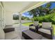 Covered patio offers comfortable seating and a serene view of the lush backyard at 1803 E Powhatan Ave, Tampa, FL 33610