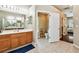 Well-lit bathroom with double vanity, wood cabinets, and a view into the toilet and walk-in closet at 2009 Raven Manor Dr, Dover, FL 33527