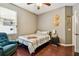 Well-lit bedroom features a ceiling fan, accent chair and wood-look flooring at 2009 Raven Manor Dr, Dover, FL 33527