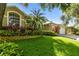 Lush landscaping and palm trees decorate this home with an attached two-car garage at 2009 Raven Manor Dr, Dover, FL 33527