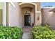 Charming front entrance with lush landscaping, an arched entry, and a black front door at 2009 Raven Manor Dr, Dover, FL 33527